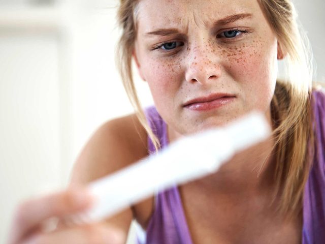 Mythes sant des femmes: une femme regarde un test de grossesse.