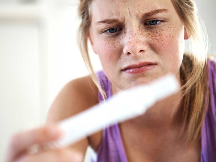 Mythes santé des femmes: une femme regarde un test de grossesse.