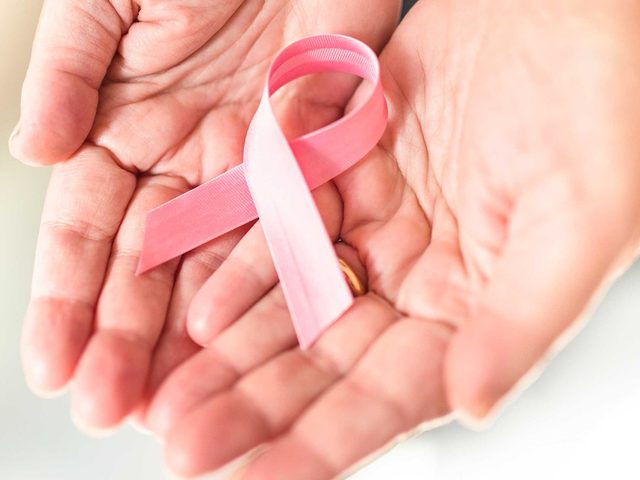 Mythes sant des femmes: une femme tient un ruban rose pour le cancer du sein.
