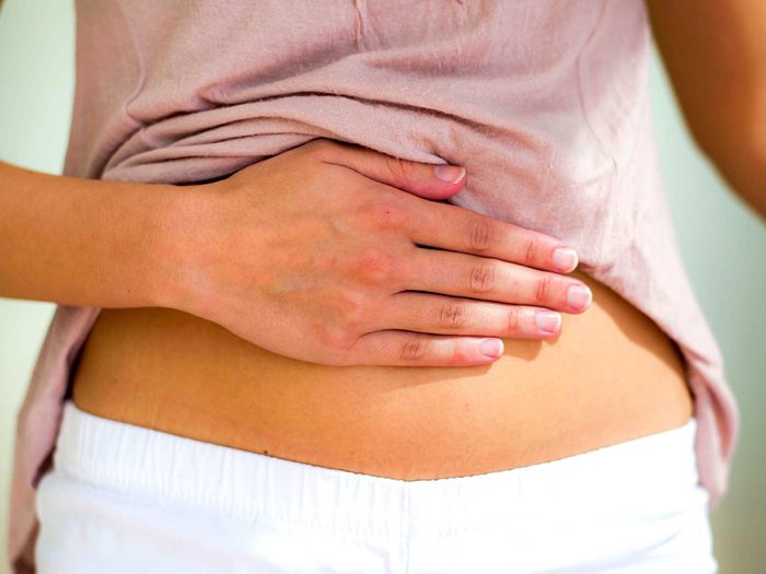 Mythes santé des femmes: une femme se tient le ventre.