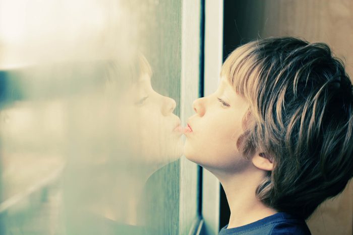 Un garçon regarde vers la fenêtre.
