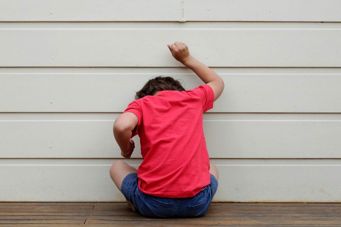 Symptômes de l’autisme: un garçon sur le bord du mur.
